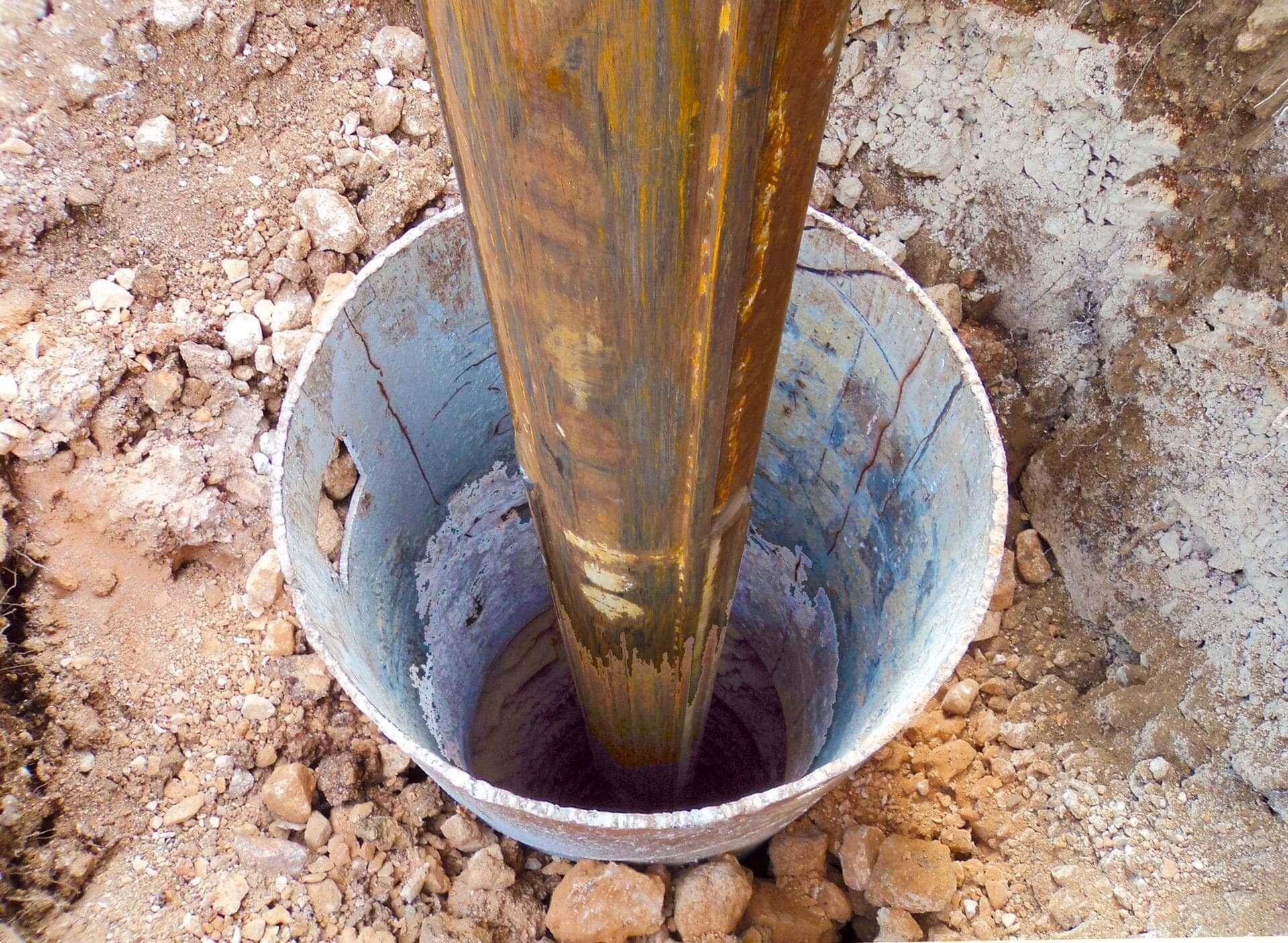 A bucket of water is in the ground.